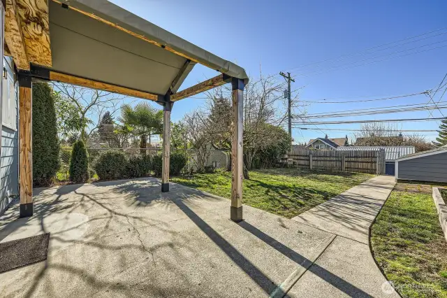 Covered back patio with a Toja Grid pergola and plenty of room to entertain.