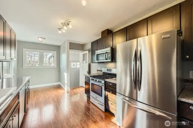 Kitchen with stainless steel appliances. Far back is the breakfast nook.