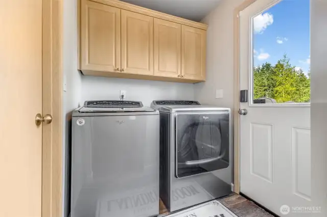Convienient laundry room with storaage and access to backyard and downstairs bathroom.