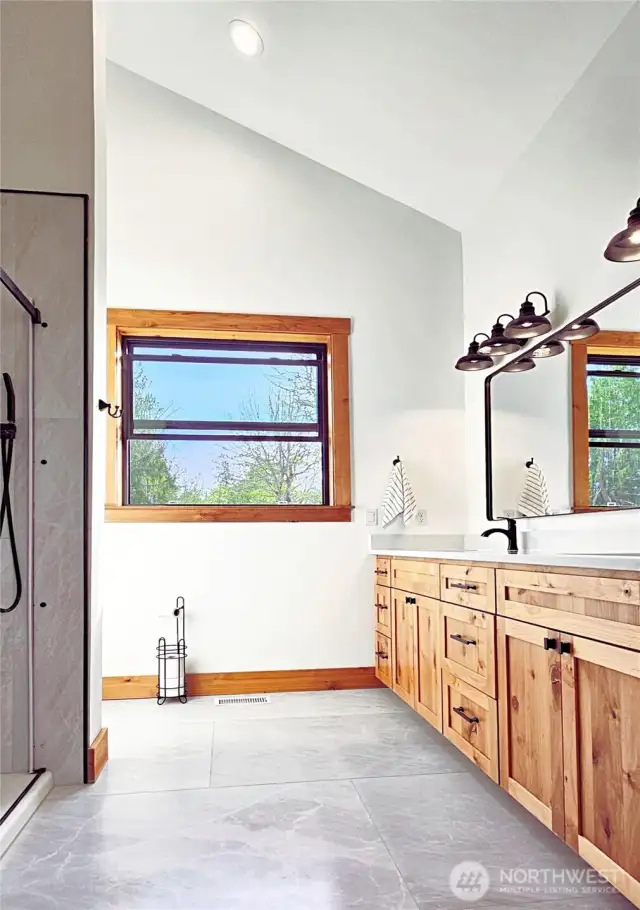 Primary en Suite Bathroom with private tiolet, large shower and plenty of cabinets.