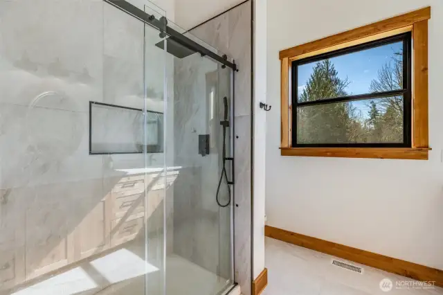 Primary Shower features tiled flooring and shower with cast iron pan.
