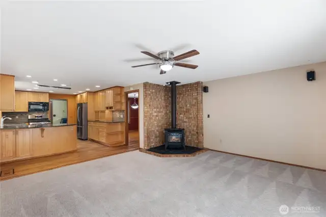 This living room is open to the kitchen and it features a cozy gas stove-perfect for winter eve snuggles.