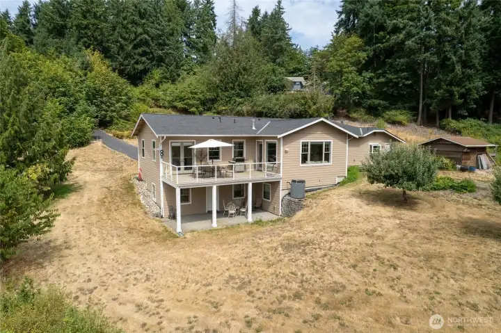 Nice view of the patio with the private entrance to the basement.  Nice out building off the right side of the house