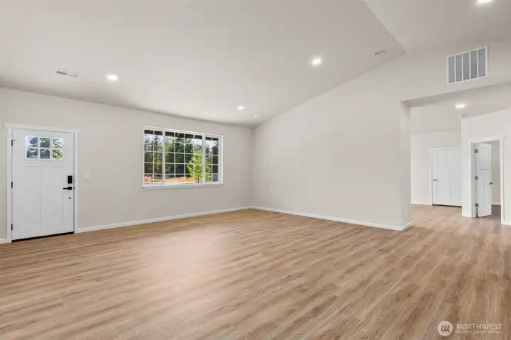 View of long driveway from the living room. Note the glass front door!