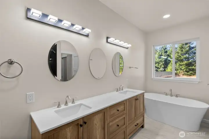 Primary ensuite with soaking tub and double vanity pictured.