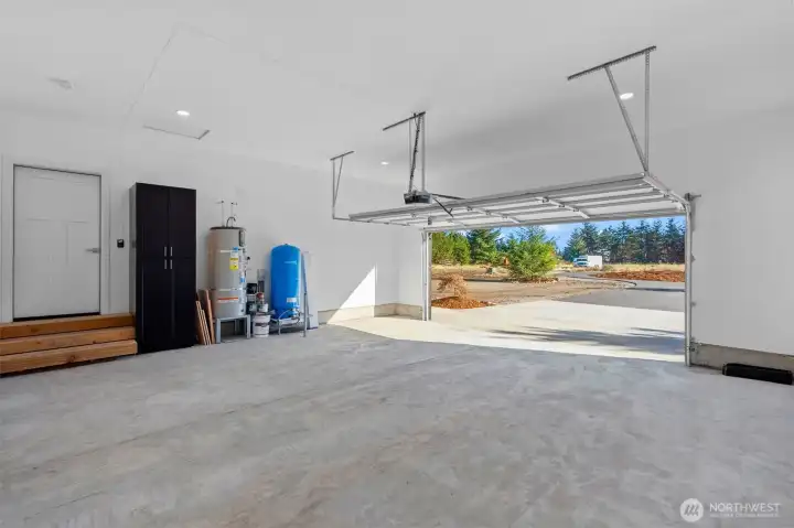 Large finished garage with storage and utility equipment.