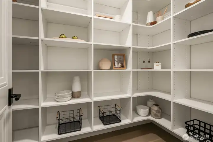 An extra-spacious walk-in pantry designed for ultimate organization, featuring motion-sensor lighting and abundant shelving to elegantly store everything from daily essentials to specialty kitchen items — where functionality meets thoughtful design.
