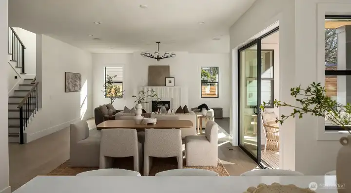 The stunning great room features soaring 10-foot ceilings, abundant natural light, and a dramatic sculptural fluted fireplace that anchors the space with architectural elegance.