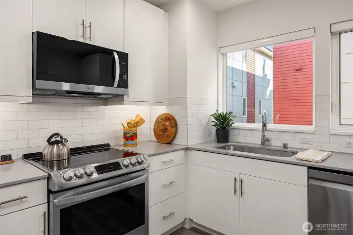 Full subway tile back splash and quartz counters showcase the quality of finishes.