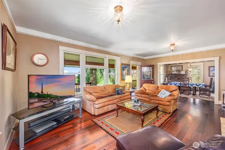 The living room features a spacious layout with large windows that offer beautiful views and plenty of natural light. The river rock fireplace with a gas insert adds warmth and charm, creating a cozy atmosphere for relaxing and entertaining.