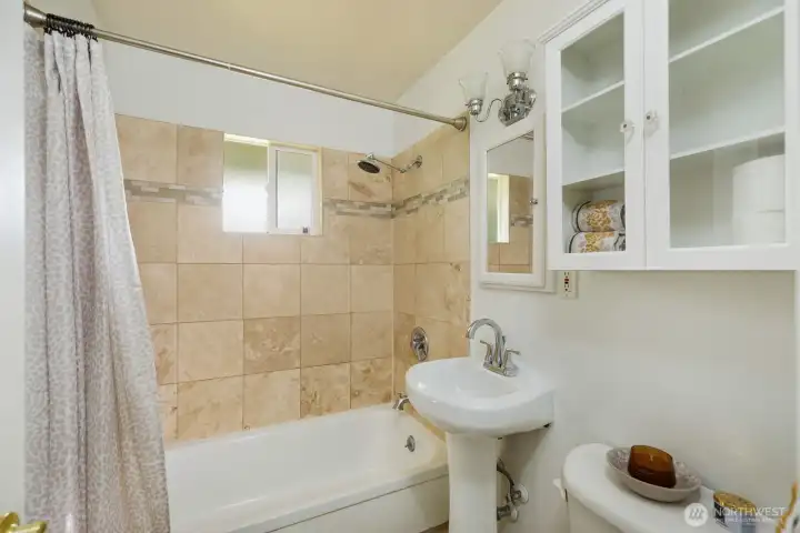 The bathroom is handsomely tiled with lots of cupboard and medicine cab conveniences. A huge linen closet in hall right otside of bathroom