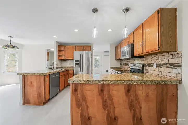 Renovated kitchen with granite tile counters and stainless steel appliances.