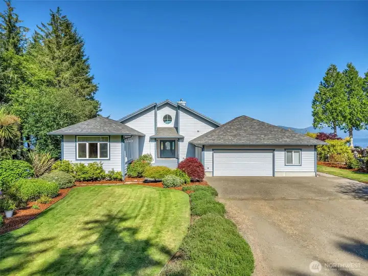 Welcoming front exterior featuring manicured landscaping, ample parking, and timeless curb appeal.