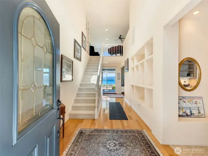 Bright and inviting entry foyer with soaring ceilings and an elegant staircase.