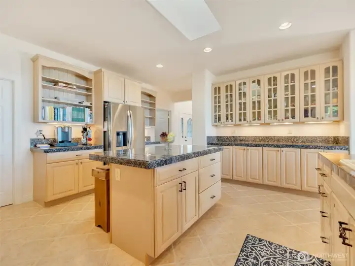Well-appointed kitchen offering extensive storage, quality finishes, and spectacular views beyond.
