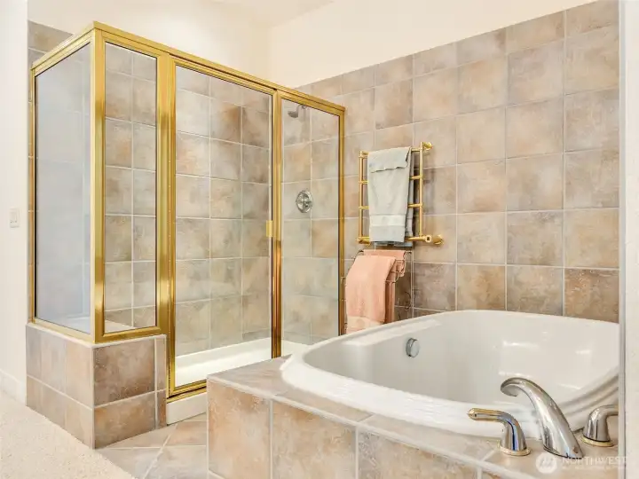 Spa-inspired primary bathroom with a soaking tub, walk-in shower, and elegant tile finishes.