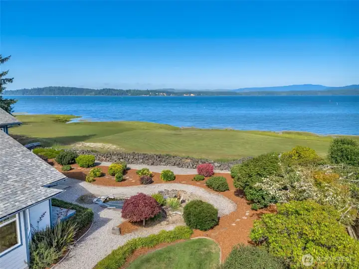 Elevated backyard perspective showcasing expansive bay views and beautifully landscaped grounds.