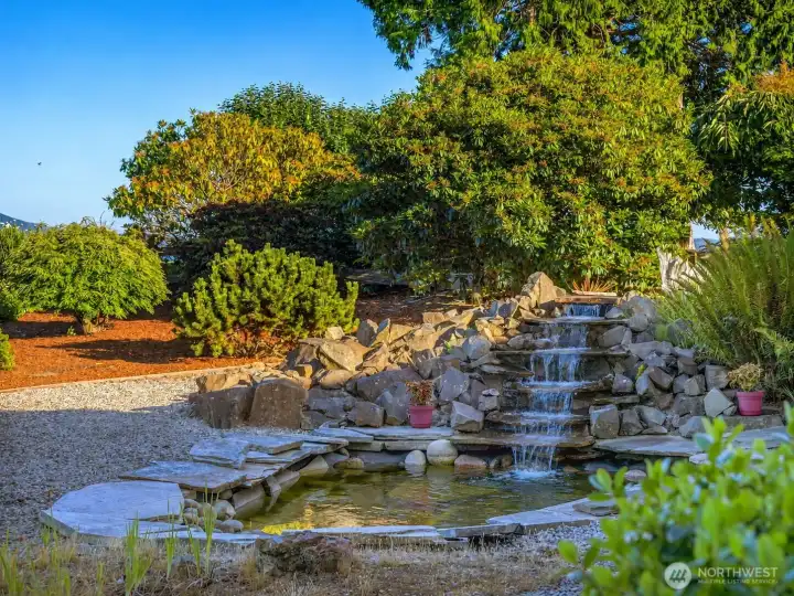 Fully landscaped backyard with custom water feature and pond.