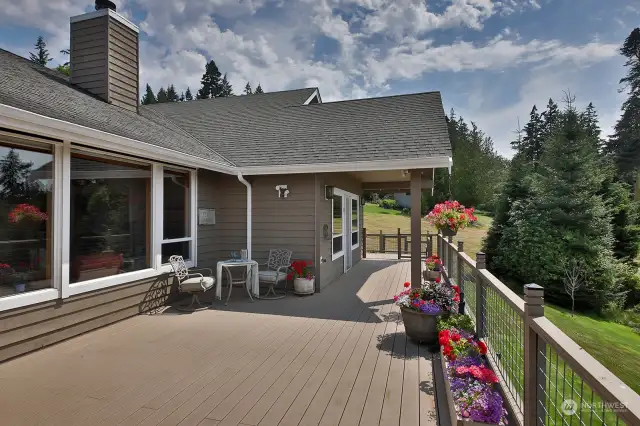 Large deck that is accessible from the dining area and primary suite and flows around the corner of the house.