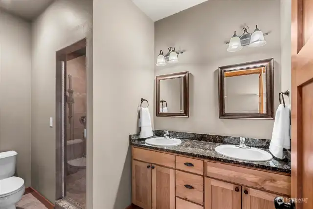 Primary Bath #2 has a custom dual vanity, toilet & walk in tile shower.