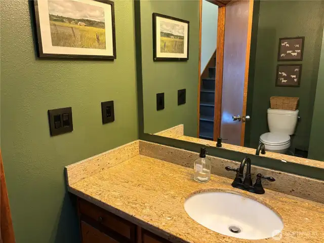 The half bath features a sleek granite countertop with an undermount sink, adding a touch of elegance and functionality to the space.