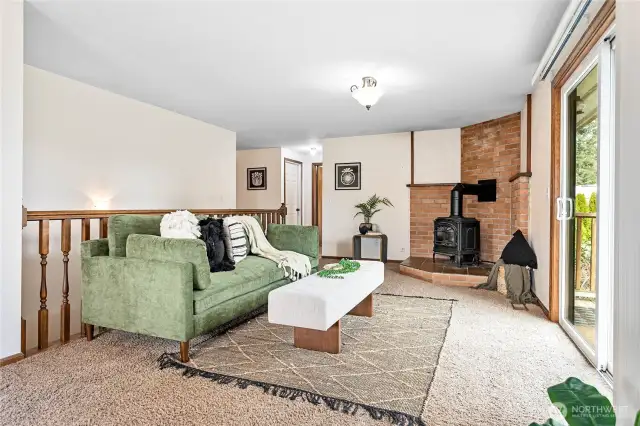 Love the cozy gas fireplace with brick surround in the family room; stairwell to basement behind couch