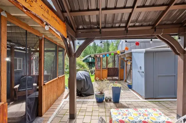 Ahead you can see the bathouse cabin. To our right there is a covered porch before entering the primary suite cabin.