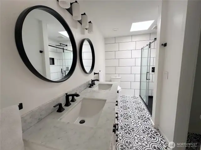 En suite bathroom with double vanity, walk in closet and shower