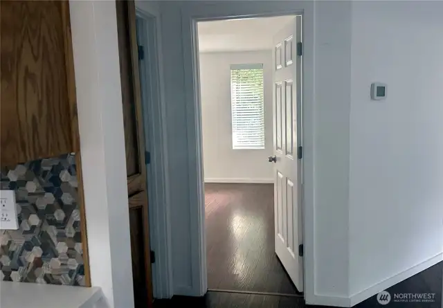 Entry to bedroom 2 between hallway, bathroom, living room and kitchen