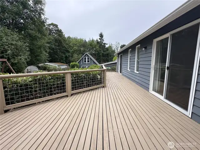The outdoor deck overlooks the garden that has a firepit.  It has three sliding doors opening onto the deck from the living room, dining room and master bedroom