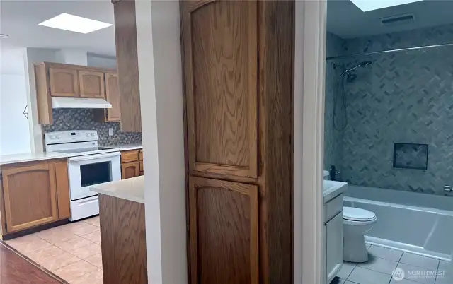 Second bathroom, pantry and kitchen accessible from hallway leading past living room