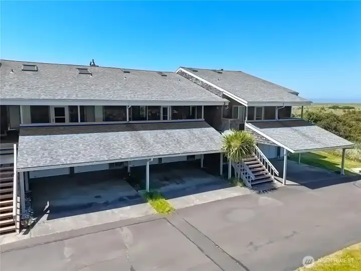Oceanfront coastal condo featuring covered parking, a two-car garage, and a spacious upper deck with direct access to dunes and sweeping ocean views.
