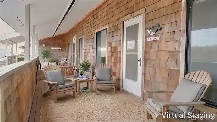Spacious covered front porch with durable cedar shingle siding, offering a sheltered outdoor living area ideal for enjoying coastal air year-round.