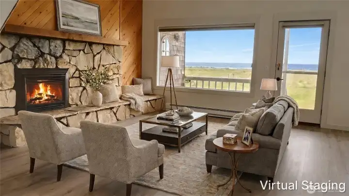 Light-filled oceanfront livingroom with a dramatic stone fireplace, vaulted wood-accent wall, and large windows and doors that showcase expansive coastal views and access to the outdoors.