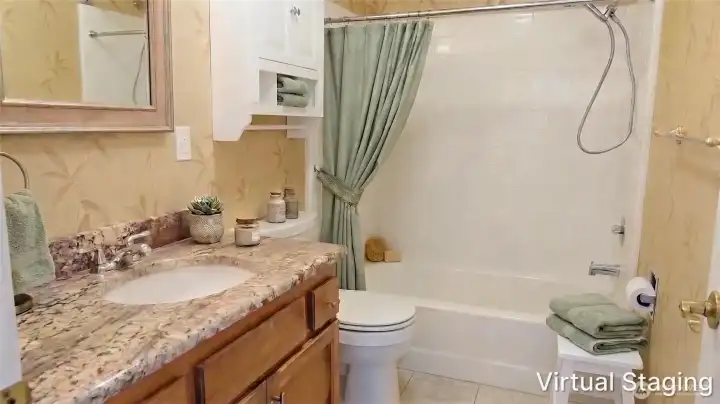 Full bathroom featuring a tub and shower combination, vanity with ample counter space, and convenient built-in storage.