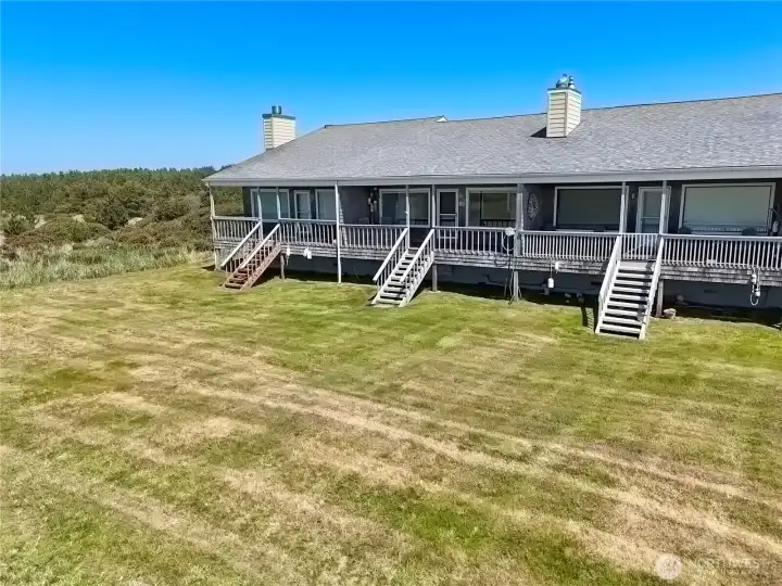 Expansive rear deck, overlooking open coastal landscape and dunes while offering ample space for outdoor enjoyment.