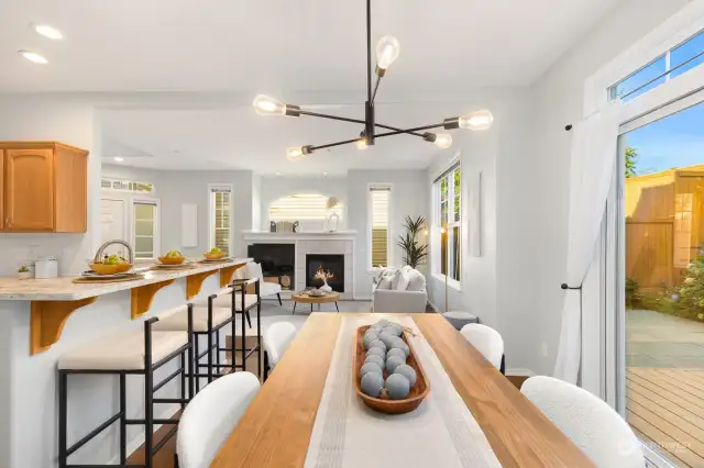 Bright and airy, this dining area features modern lighting and flows seamlessly into the kitchen for easy entertaining.