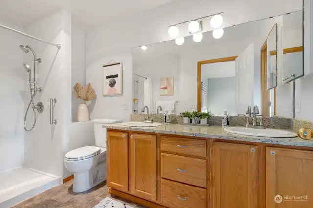 Relax and rejuvenate in this bright primary ensuite, offering a spa-like atmosphere with its modern walk-in shower and elegant vanity.