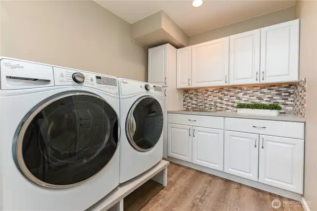 The spacious laundry room is designed with a dedicated laundry station, featuring plenty of storage, counter space, and thoughtful organization to make chores easier and more efficient.