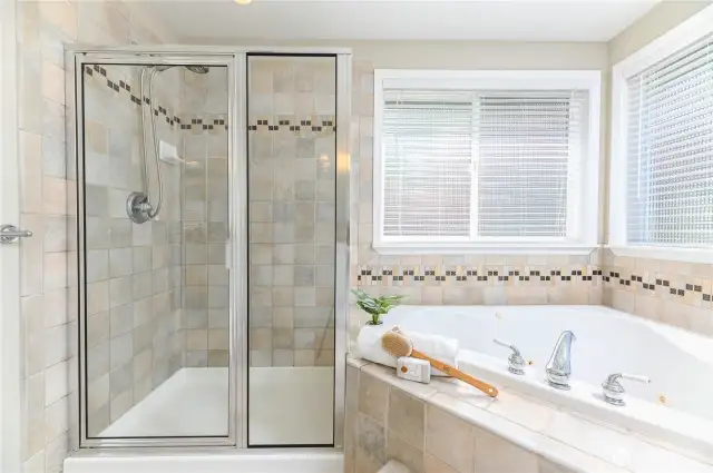 The spa-inspired bath features a luxurious walk-in shower with elegant finishes and a separate jetted soaking tub, offering the perfect combination of relaxation and comfort.