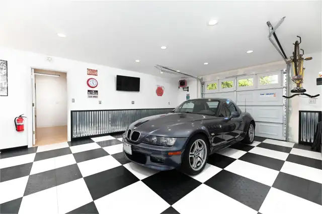 The showroom bay of the detached garage is a true highlight, featuring a game area and a stunning live-edge wood bar. Replace the mirror with a TV, and you’ve got your own year-round drive-in experience.