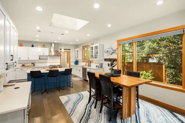 White Oak hardwood floors flow throughout the main level into a spacious family room with one of two fireplaces with travertine tile surround, built-in bookcases, cabinets and views to the outdoor space.