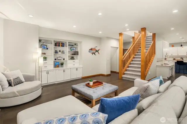 White Oak hardwood floors flow throughout the main level into a spacious family room with one of two fireplaces with travertine tile surround, built-in bookcases, cabinets and views to the outdoor space.