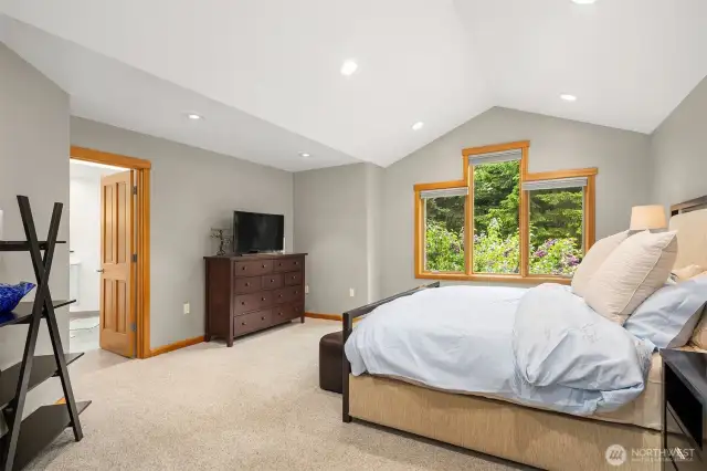 The large primary bedroom suite features cathedral ceilings, and provides a relaxing respite. Evident quality with solid core 4-panel doors, wood-wrapped windows and Graber 2-way blinds throughout.