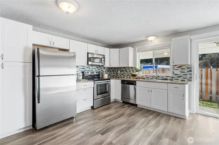 Enjoy the updated kitchen with granite countertops, sparkling stainless appliances, shaker cabinetry and full-height tiled backsplash.