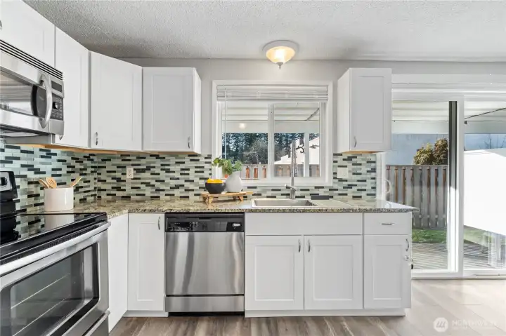 Kitchen window and slider door allows light to pour into the open kitchen and dining nook.