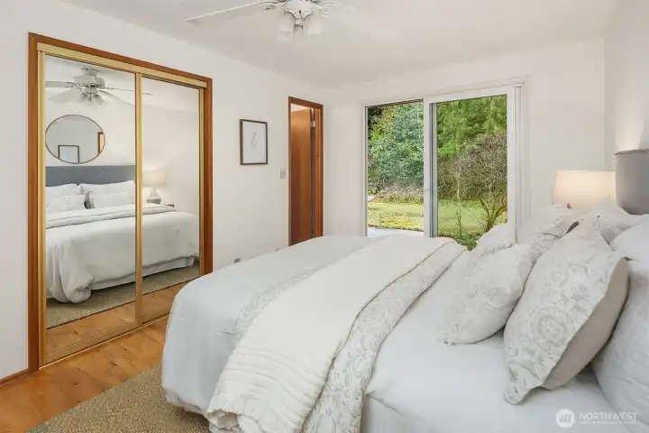 Relax and unwind in this primary bedroom with mirrored closet doors, a private 1/2 Bath and sliding glass door to the outdoors.