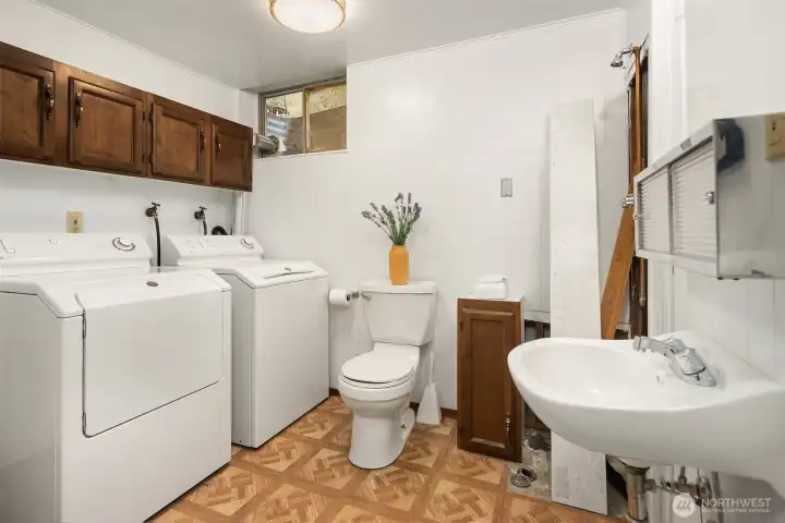 Dedicated powder room plumbed for a shower stall/ laundry area with additional storage—practical, efficient, and full of potential.