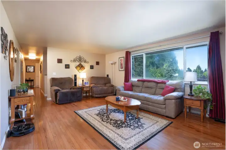 The living room is large and has gleaming wood floors.  To one end of the home are bedrooms and bathrooms and at the other end, we find a dining room and kitchen great room concept.  Let's go.