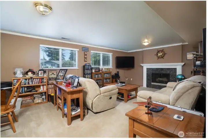 Downstairs, you'll find a large recreation room with room for media, games, hobbies, comfy furniture, and more, and the wood fireplace adds a cozy touch.